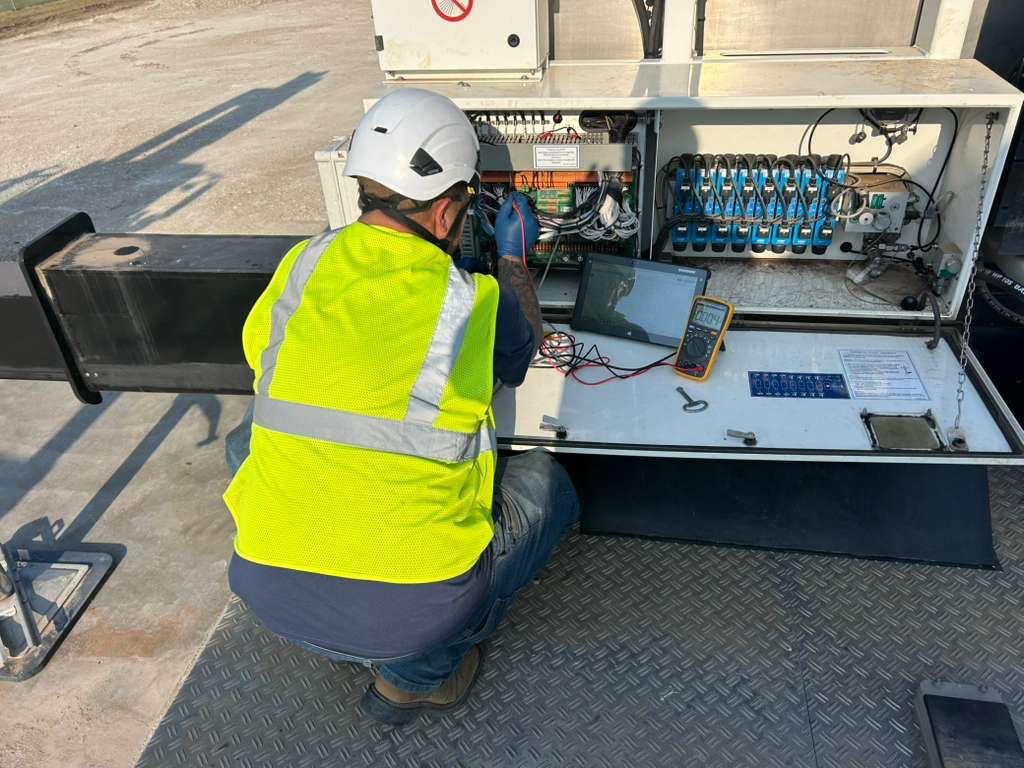 Blade Platforms service technician testing a truck-mounted platform control box